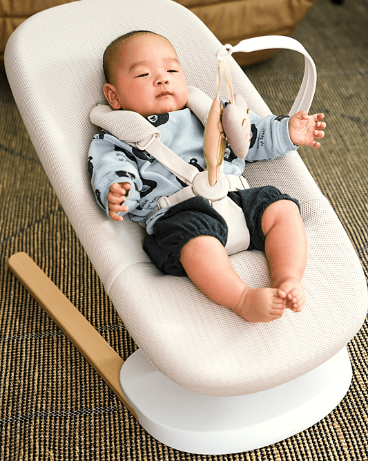 baby lounges in stokke yoga bouncer in a livingroom setting