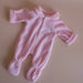 Pink baby doll onesie on a beige background