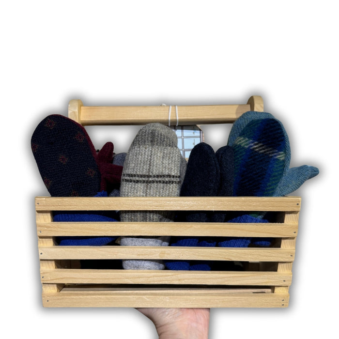 Wooden crate holding pairs of mittens on a white background