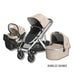 Beige and black stroller set with car seat and bassinet on a white background