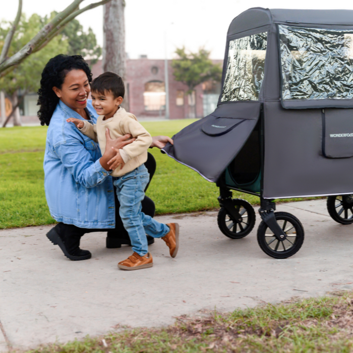Woman and child with a wagon stroller in a park setting