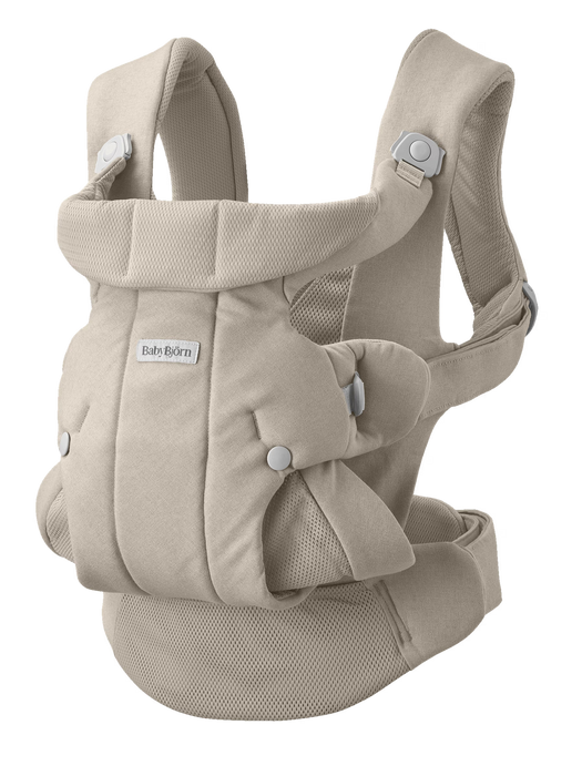 Cream coloured mesh and canvas baby carrier with buckles on white background with Baby Bjorn logo on front. 