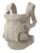 Cream coloured mesh and canvas baby carrier with buckles on white background with Baby Bjorn logo on front. 