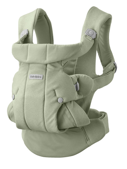 Light  green mesh and canvas baby carrier with buckles on white background with Baby Bjorn logo on front. 