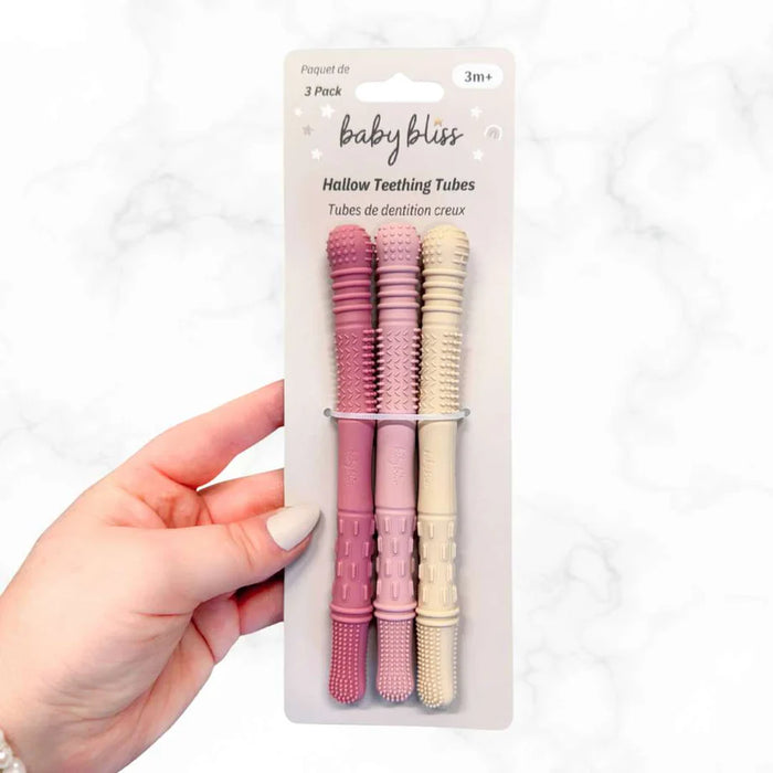 Hand holding a package of baby teething tubes with 'baby bliss' branding.