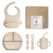 Baby feeding set with bib, plate, cups, and spoons on a white background