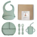 Baby feeding set with bib, plate, cups, and spoons on a white background
