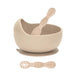 Beige bowl, spoon, and suction cup on a white background