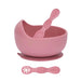 Pink bowl, spoon, and suction cup on a white background