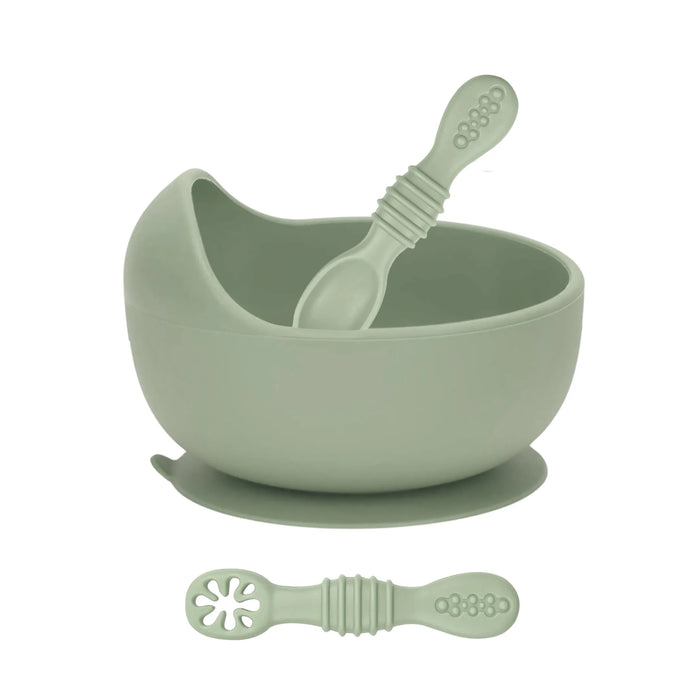 Green bowl, spoon, and suction cup on a white background
