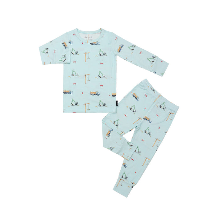 Children's pajama set with construction vehicle pattern on a light blue background
