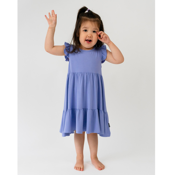Child wearing a blue dress on a white background