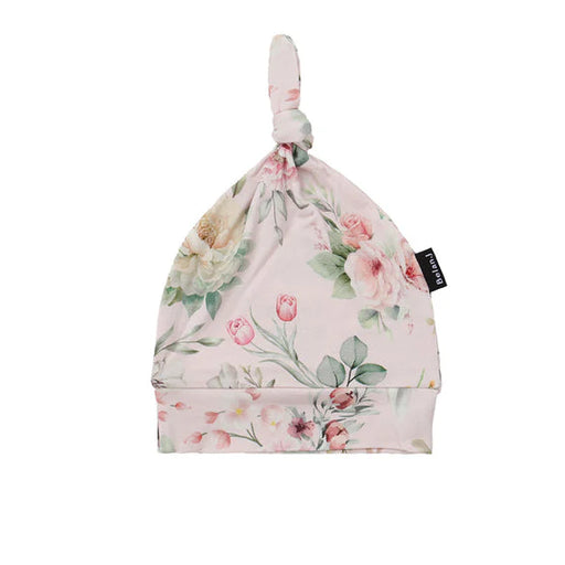 Floral patterned baby hat with a brand label on a white background