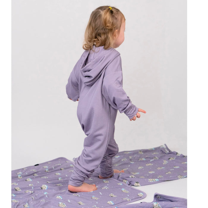 Child wearing a purple onesie on a white background