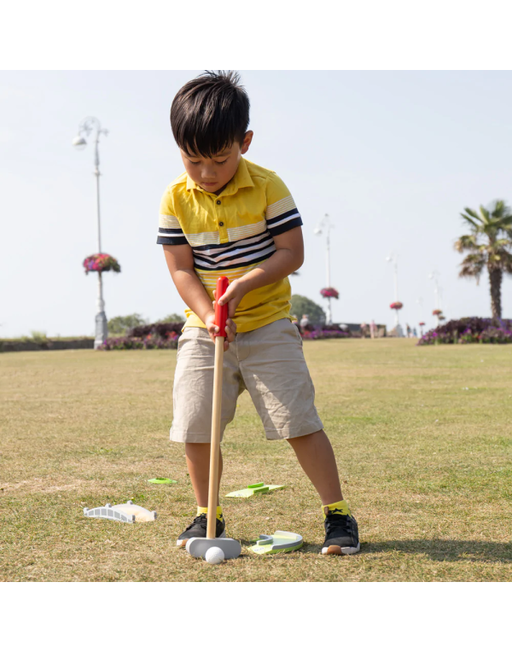 caption-Child plays with wooden golf set