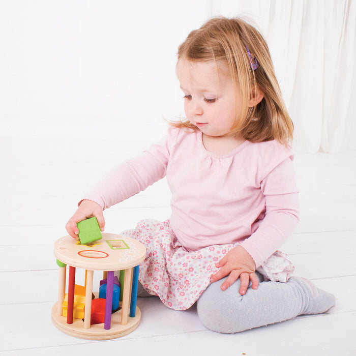 caption-Child plays with wooden shape sorter