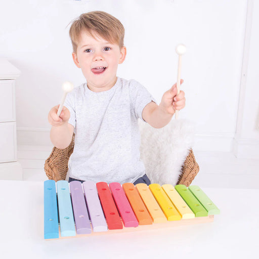caption-Child holds wooden mallets in front of Snazzy Children's Xylophone