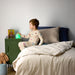 Child sitting on a bed holding a glowing night light in a bedroom setting.