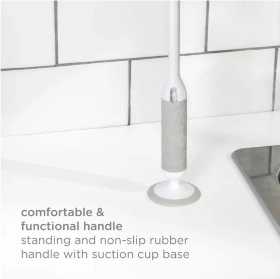 Handheld cleaning tool with suction cup base on a kitchen counter