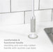 Handheld cleaning tool with suction cup base on a kitchen counter