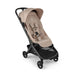 A modern Bugaboo stroller in light beige and black, shown from a three-quarters angle against a plain white background.