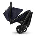 Black stroller with navy rain cover on a white background