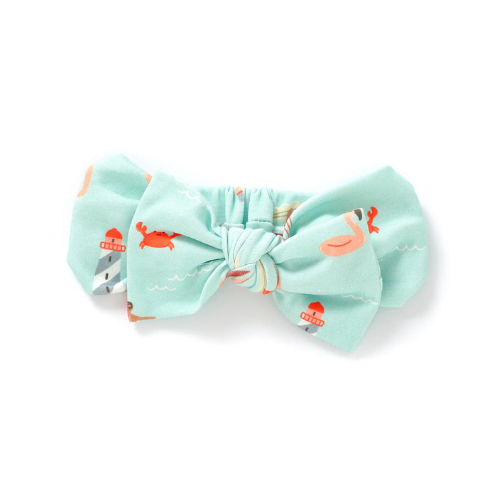 Mint green bow headband with flamingo pattern on a white background