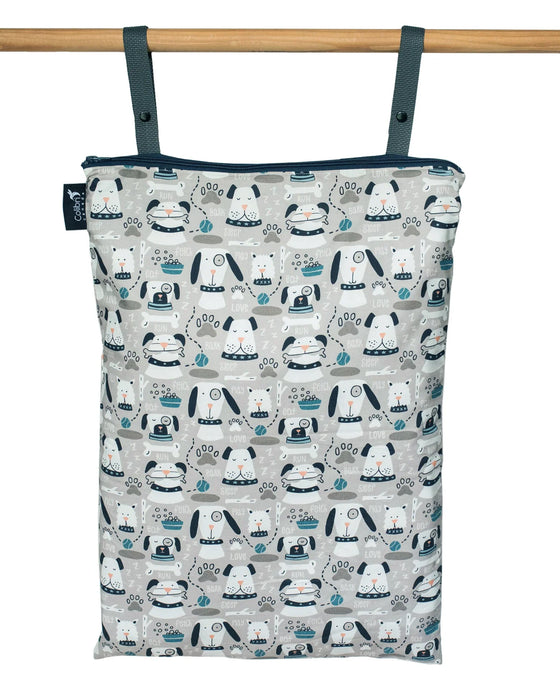 Patterned reusable wet bag with dogs hanging on a wooden rod with a white background