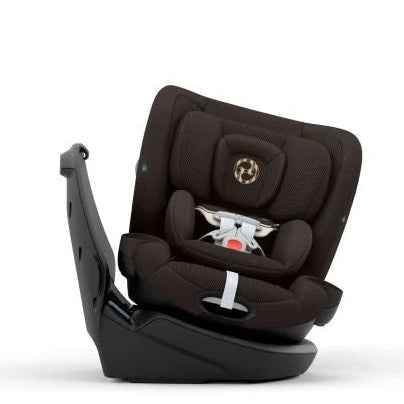 A dark brown and black rotating infant car seat with a white and black patterned safety harness insert, shown from a three-quarters angle on a white background.