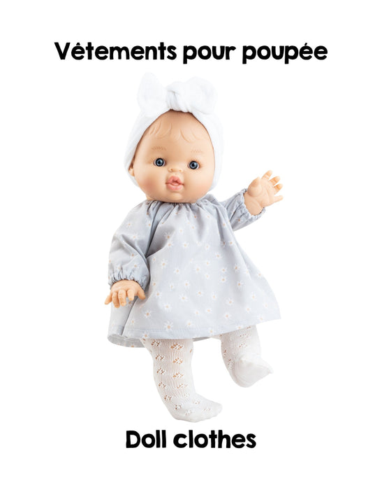 Doll wearing a gray dress with text 'Vétements pour poupèe' and 'Doll clothes' on a white background