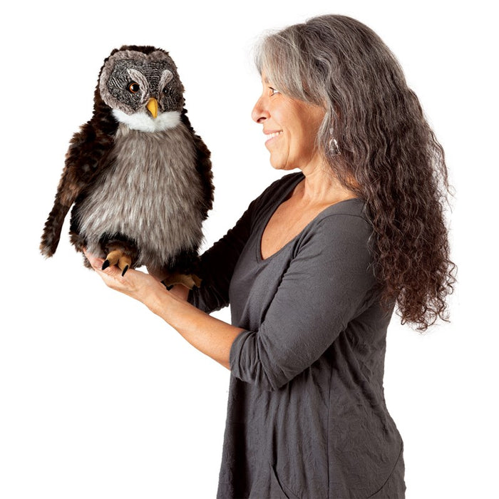 Woman holding a plush owl toy against a white background