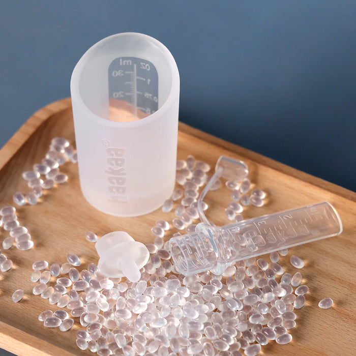 Silicone mold with measurement markings on a wooden surface with clear silicone beads.