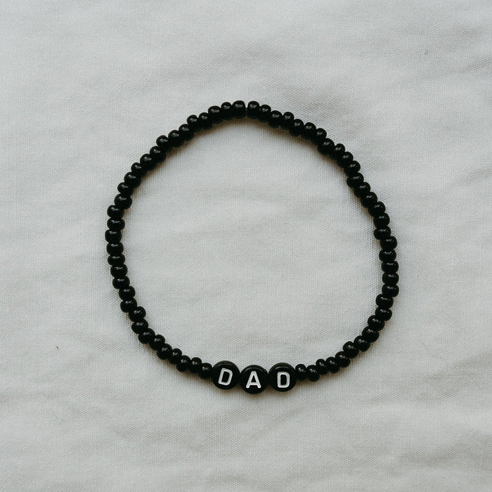 black beaded bracelet with DAD letters on a light background
