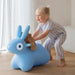 Child playing with a blue toy rabbit indoors