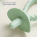 Green baby teether with textured design on a light beige background