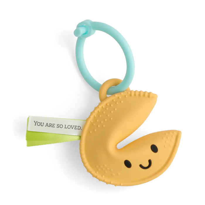 Yellow fortune cookie-shaped teething toy with a smiley face on a white background.Text on a ribbon reads You are so loved.