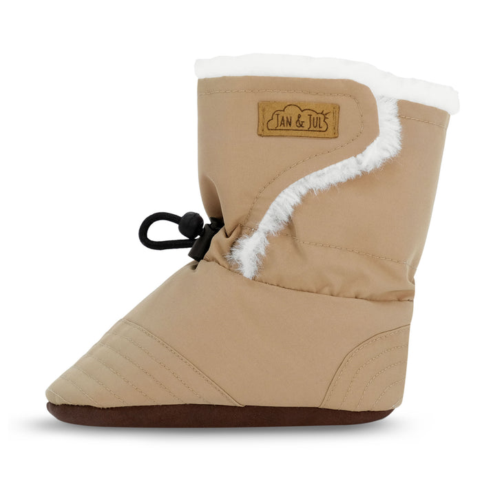 Tan baby bootie with white fur lining on a white background