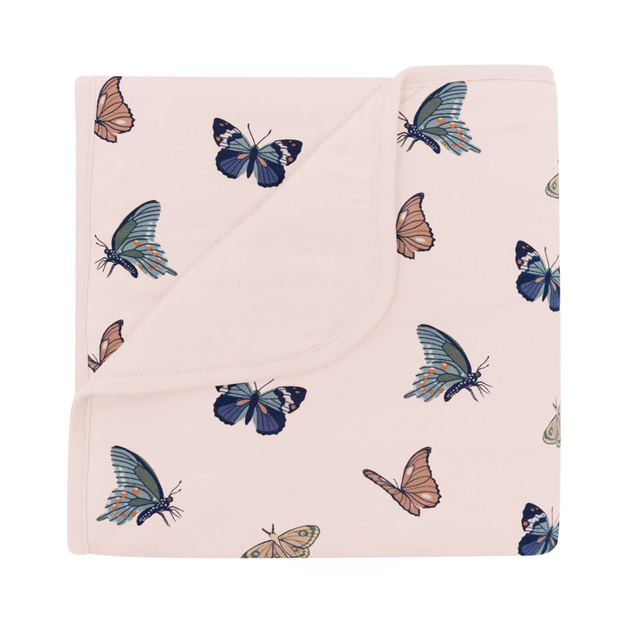 Blanket with butterfly pattern on a light pink background