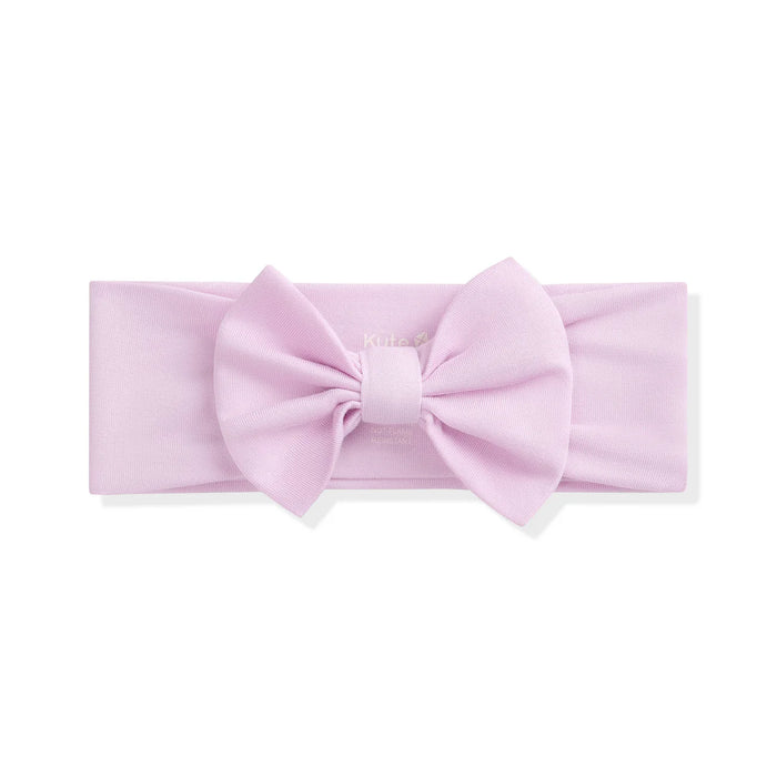 Pink headband with a large bow on a white background