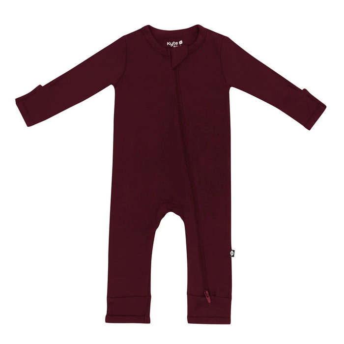 A zippered burgundy Kyte Baby romper for babies on a white background