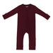 A zippered burgundy Kyte Baby romper for babies on a white background