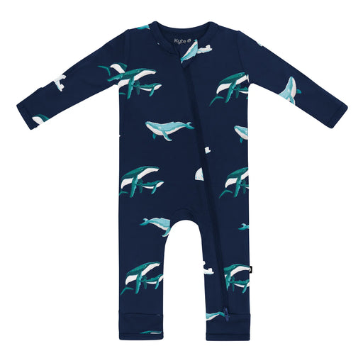 Navy blue baby long sleeved romper onesie with humpback whale pattern against a white background