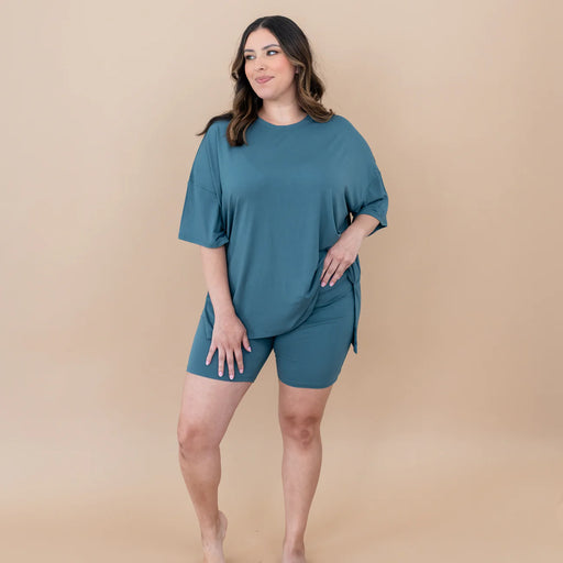 Woman wearing a teal outfit on a beige background