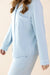 Light blue pajama set worn by a person on a beige background
