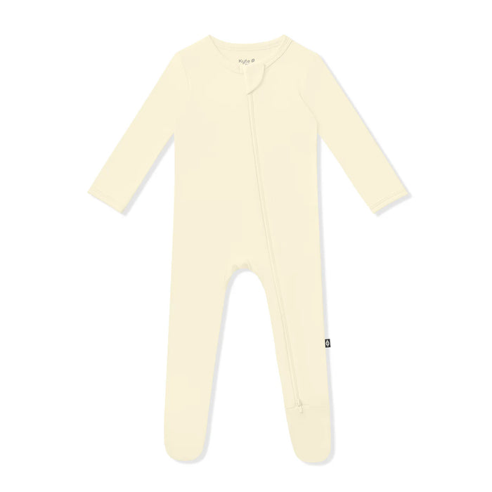 Cream-colored baby onesie with feet on a white background
