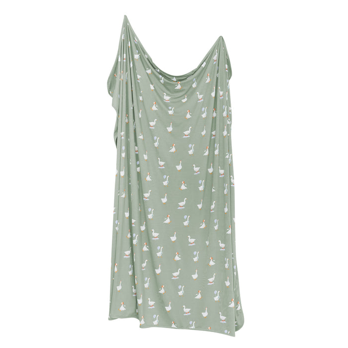 Silly goose Green blanket with goose pattern on a white background