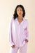 Woman wearing a light purple pajama set against a beige background