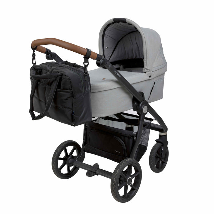 Black Diaper bag attaches to baby stroller on a white background