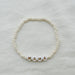 Ivory glass beaded MAMA bracelet against a white background