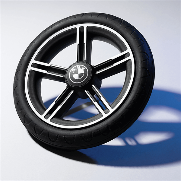 Black BMW wheel on a reflective surface with a blurred background